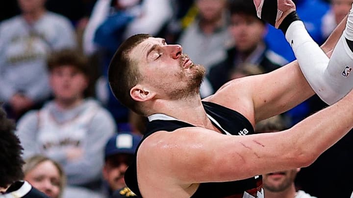 Feb 11, 2026; Denver, Colorado, USA; Memphis Grizzlies center Lawson Lovering (34) passes the ball against Denver Nuggets center Nikola Jokic (15) and guard Jamal Murray (27) in the fourth quarter at Ball Arena. Mandatory Credit: Isaiah J. Downing-Imagn Images