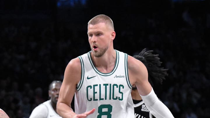 Mar 15, 2025; Brooklyn, New York, USA; Boston Celtics center Kristaps Porzingis (8) drives to the basket while being defended by Brooklyn Nets guard Tyrese Martin (13) during the second half at Barclays Center. Mandatory Credit: John Jones-Imagn Images