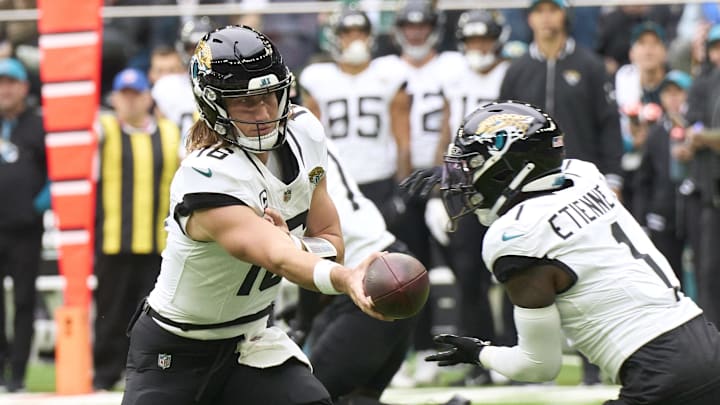Oct 13, 2024; London, United Kingdom; Jacksonville Jaguars quarterback Trevor Lawrence (16) passes to 	Jacksonville Jaguars running back Travis Etienne Jr. (1) during the first half of an NFL International Series game at Tottenham Hotspur Stadium. Mandatory Credit: Peter van den Berg-Imagn Images