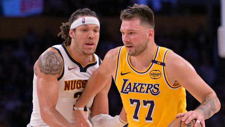 Mar 19, 2025; Los Angeles, California, USA;  Los Angeles Lakers guard Luka Doncic (77) is guarded by Denver Nuggets forward Aaron Gordon (32) in the first half at Crypto.com Arena.