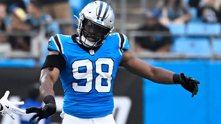 Aug 8, 2025; Charlotte, North Carolina, USA; Carolina Panthers linebacker D.J. Wonnum (98) reacts with cornerback Chau Smith-Wade (26) in the first quarter at Bank of America Stadium.