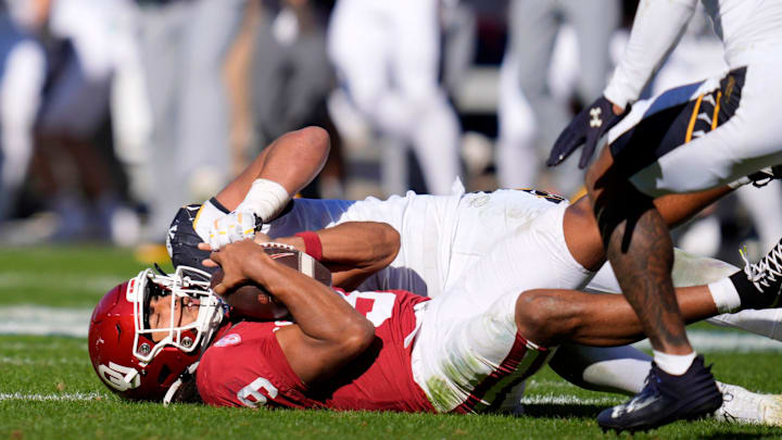 Oklahoma quarterback Michael Hawkins Jr. absorbs a hit against Navy. Oklahoma quarterback Michael Hawkins Jr. absorbs a hit against Navy.