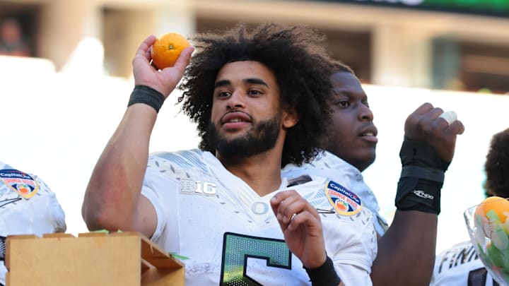 Jan 1, 2026; Miami Gardens, FL, USA; Oregon Ducks linebacker Devon Jackson (26) and quarterback Dante Moore (5) celebrate following the 2025 Orange Bowl and quarterfinal game of the College Football Playoff against the Texas Tech Red Raiders at Hard Rock Stadium. Mandatory Credit: Sam Navarro-Imagn Images