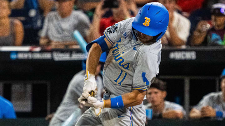 Jun 17, 2025; Omaha, Neb, USA; UCLA Bruins center fielder Payton Brennan (11) hits a RBI single against the Arkansas Razorbacks during the ninth inning at Charles Schwab Field. Mandatory Credit: Dylan Widger-Imagn Images