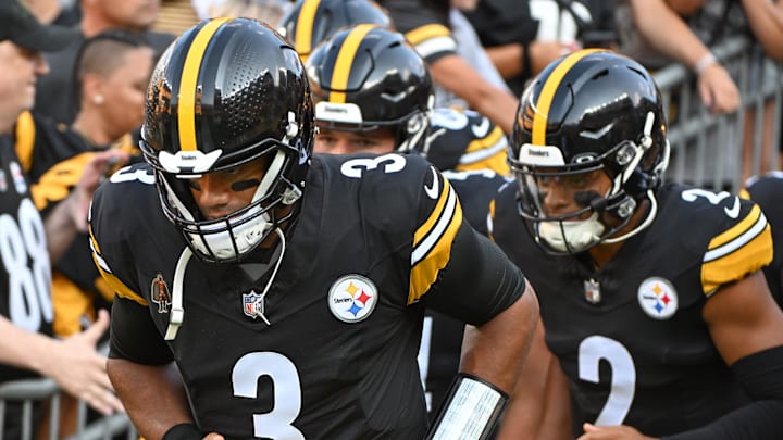 Pittsburgh Steelers quarterbacks Russell Wilson and Justin Fields run onto the field before the game.