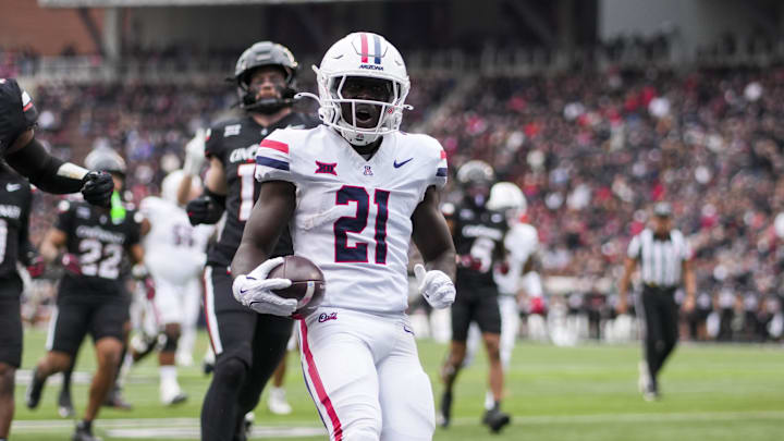 Nov 15, 2025; Cincinnati, Ohio, USA; Arizona Wildcats running back Ismail Mahdi (21) carries the ball for a touchdown against the Cincinnati Bearcats in the first half at Nippert Stadium. Mandatory Credit: Aaron Doster-Imagn Images Nov 15, 2025; Cincinnati, Ohio, USA; Arizona Wildcats running back Ismail Mahdi (21) carries the ball for a touchdown against the Cincinnati Bearcats in the first half at Nippert Stadium. Mandatory Credit: Aaron Doster-Imagn Images
