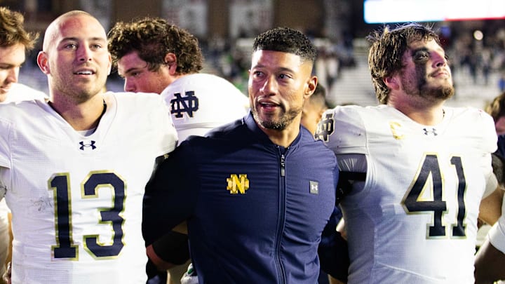 Notre Dame Fighting Irish head coach Marcus Freeman, quarterback CJ Carr (13) and defensive lineman Donovan Hinish (41) celebrate a win over Boston College at Alumni Stadium.