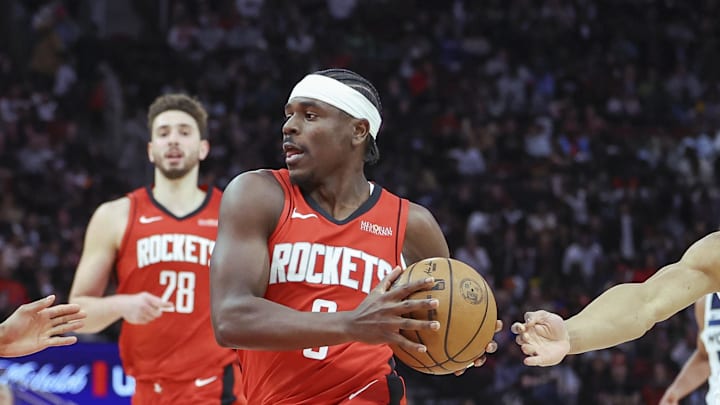 Feb 21, 2025; Houston, Texas, USA; Houston Rockets guard Aaron Holiday (0) drives with the ball as Minnesota Timberwolves guard Nickeil Alexander-Walker (9) and guard Jaylen Clark (22) defend during the game at Toyota Center. Mandatory Credit: Troy Taormina-Imagn Images
