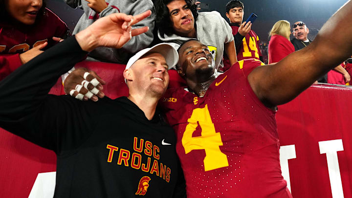 Nov 29, 2025; Los Angeles, California, USA; Southern California Trojans head coach Lincoln Riley (right) and defensive tackle Jahkeem Stewart (4) pose with fans after the game against the UCLA Bruins at United Airlines Field at Los Angeles Memorial Coliseum. Mandatory Credit: Kirby Lee-Imagn Images Nov 29, 2025; Los Angeles, California, USA; Southern California Trojans head coach Lincoln Riley (right) and defensive tackle Jahkeem Stewart (4) pose with fans after the game against the UCLA Bruins at United Airlines Field at Los Angeles Memorial Coliseum. Mandatory Credit: Kirby Lee-Imagn Images