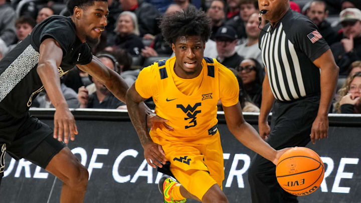 Feb 5, 2026; Cincinnati, Ohio, USA;  West Virginia Mountaineers guard Honor Huff (3) dribbles the ball against Cincinnati Bearcats guard Sencire Harris (5) in the second half at Fifth Third Arena. Mandatory Credit: Aaron Doster-Imagn Images