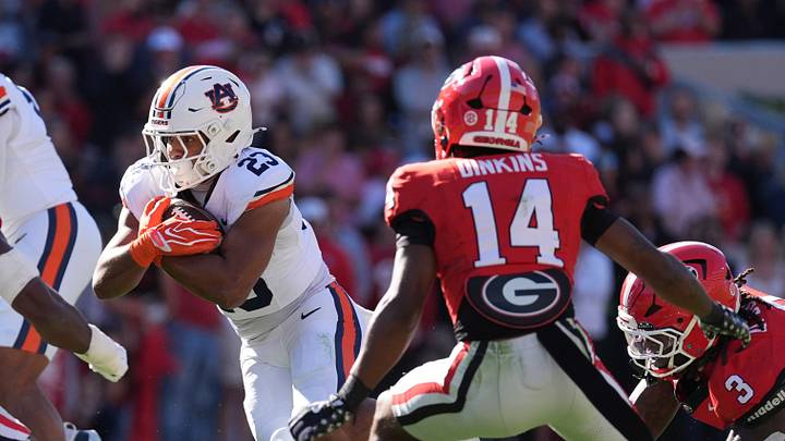 Oct 17, 2026; Athens, Georgia, USA;  Auburn running back Jeremiah Cobb (23) runs for a gain past Georgia linebacker Justin Williams (19) during the first quarter at Sanford Stadium.  Mandatory Credit: Dale Zanine-Imagn Images