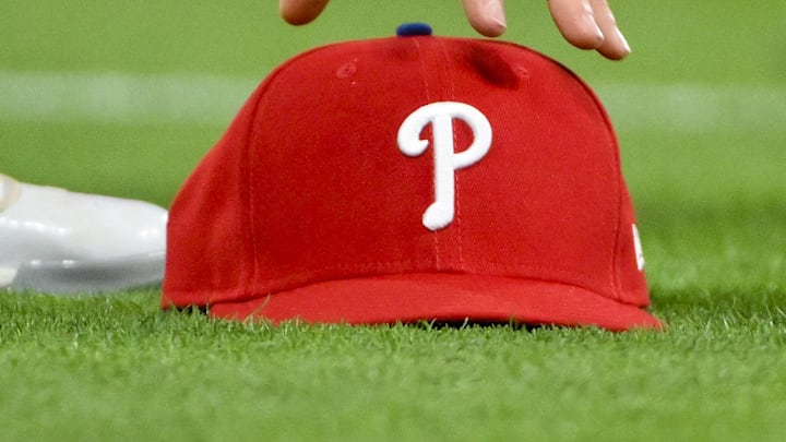 Apr 11, 2025; St. Louis, Missouri, USA;  Philadelphia Phillies third baseman Alec Bohm (28) picks up his hat after chasing down a fly ball against the St. Louis Cardinals during the third inning at Busch Stadium. 