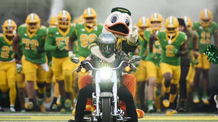 Nov 9, 2024; Eugene, Oregon, USA; The Duck rides a motorcycle and the Oregon Ducks take the field before a game against the Maryland Terrapins at Autzen Stadium.
