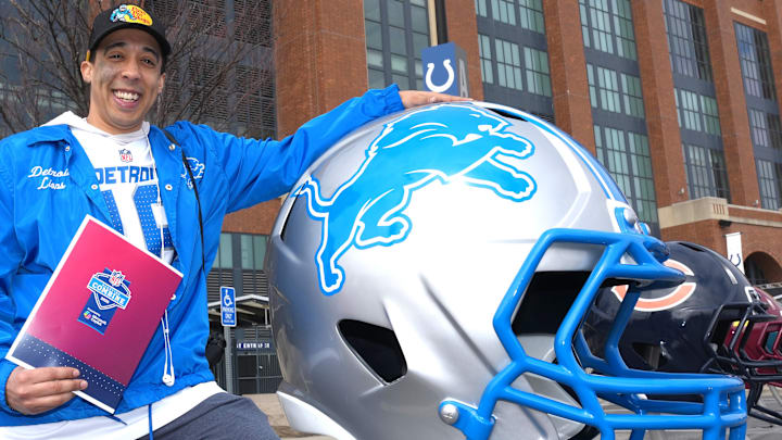 Marcus Thatcher poses with large Detroit Lions helmet at the NFL Scouting Combine Experience at Lucas Oil Stadium