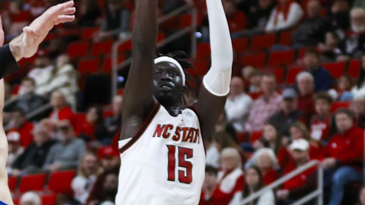 Dec 6, 2025; Raleigh, North Carolina, USA; NC State Wolfpack forward Jerry Deng (15) shoots a 3-pointer past UNC Asheville Bulldogs guard Corey Jones (24) during the first half of the game at Lenovo Center. Mandatory Credit: Jaylynn Nash-Imagn Images