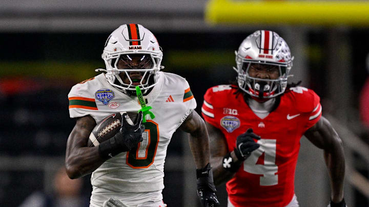 Dec 31, 2025; Arlington, TX, USA; Miami Hurricanes defensive back Keionte Scott (0) returns an interception for a touchdown as Ohio State Buckeyes wide receiver Jeremiah Smith (4) chases during the 2025 Cotton Bowl and quarterfinal game of the College Football Playoff at AT&T Stadium. Mandatory Credit: Jerome Miron-Imagn Images