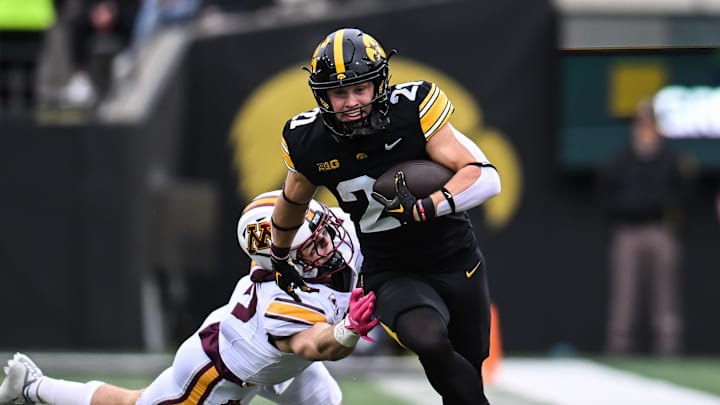 Oct 25, 2025; Iowa City, Iowa, USA; Iowa Hawkeyes wide receiver Kaden Wetjen (21) gets yards after the catch as Minnesota Golden Gophers defensive back Kerry Brown (14) attempts the tackle during the first quarter at Kinnick Stadium. Mandatory Credit: Jeffrey Becker-Imagn Images