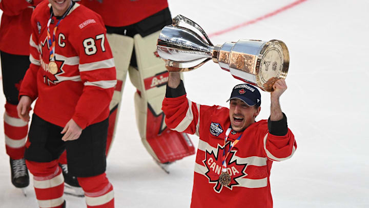 Marchand lift the trophy following Team Canada's 4 Nations Face-Off win.