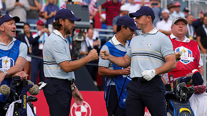 Tommy Fleetwood and Rory McIlroy of Team Europe fist bump  during the Friday morning foursomes matches.