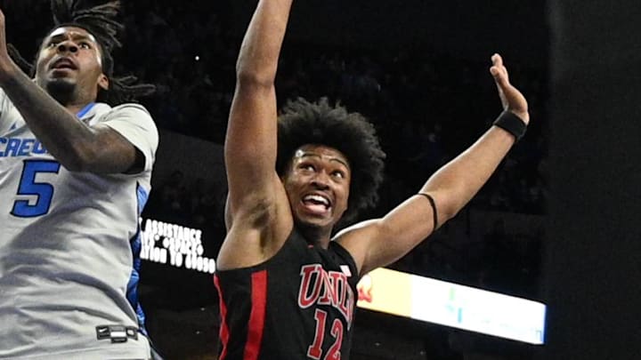Dec 7, 2024; Omaha, Nebraska, USA;  Creighton Bluejays guard Jamiya Neal (5) scores against UNLV Rebels forward Jacob Bannarbie (12) in the second half at CHI Health Center Omaha. Mandatory Credit: Steven Branscombe-Imagn Images