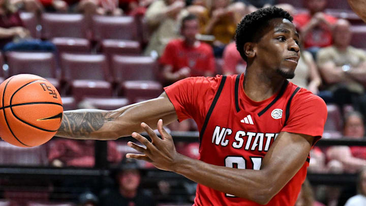 Jan 10, 2026; Tallahassee, Florida, USA; North Carolina State Wolfpack guard Terrance Arceneaux (21) passes the ball as Florida State Seminoles guard Kobe MaGee (5) looks on during the second half at Donald L. Tucker Center. Mandatory Credit: Melina Myers-Imagn Images