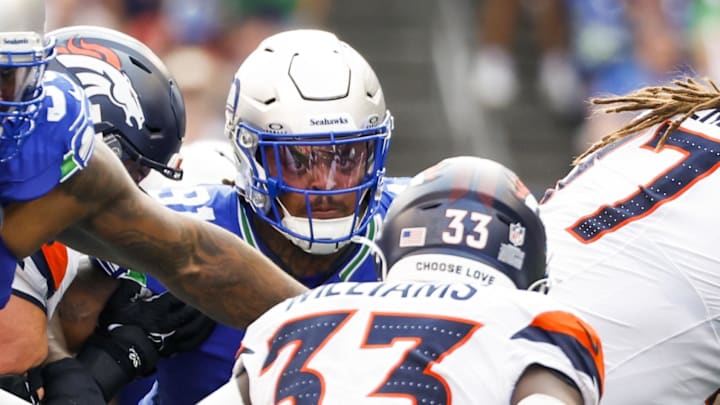 Sep 8, 2024; Seattle, Washington, USA; Seattle Seahawks defensive end Leonard Williams (99) and Seattle Seahawks defensive tackle Byron Murphy II (91) tackle Denver Broncos running back Javonte Williams (33) for a loss during the fourth quarter at Lumen Field.