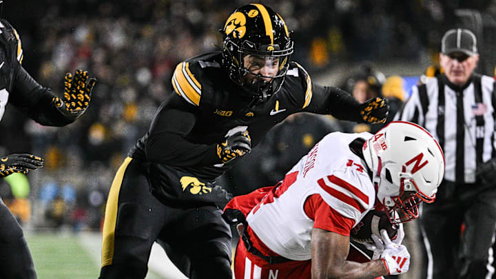 Nov 29, 2024; Iowa City, Iowa, USA; Nebraska Cornhuskers wide receiver Jahmal Banks (4) is knocked out of bounds by Iowa Hawkeyes defensive back Xavier Nwankpa (1) as defensive lineman Ethan Hurkett (49) chases during the second quarter at Kinnick Stadium. Mandatory Credit: Jeffrey Becker-Imagn Images
