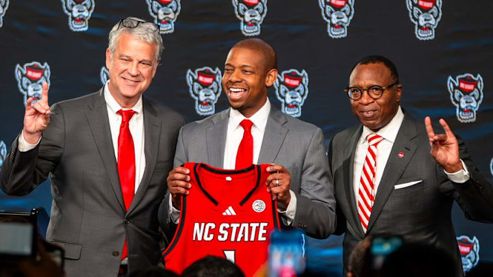 NC State AD Boo Corrigan, men's basketball coach Justin Gainey and Chancellor Kevin Howell pose at Gainey's introductory press conference at the Lenovo Center on Wednesday, April 1, 2026. 