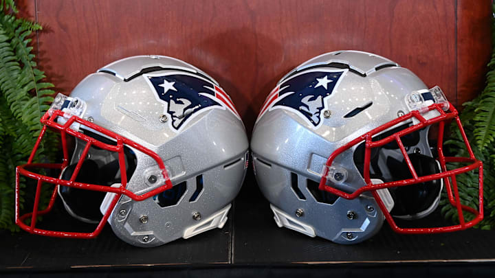 Jan 13, 2025; Foxborough, MA, USA; A pair of New England Patriots helmets sit in front of the podium before a press conference at Gillette Stadium. Mandatory Credit: Eric Canha-Imagn Images Jan 13, 2025; Foxborough, MA, USA; A pair of New England Patriots helmets sit in front of the podium before a press conference at Gillette Stadium. Mandatory Credit: Eric Canha-Imagn Images