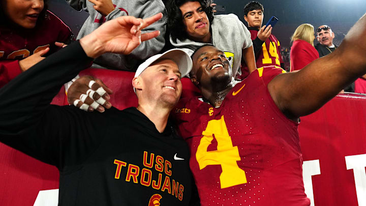 Nov 29, 2025; Los Angeles, California, USA; Southern California Trojans head coach Lincoln Riley (right) and defensive tackle Jahkeem Stewart (4) pose with fans after the game against the UCLA Bruins at United Airlines Field at Los Angeles Memorial Coliseum. Mandatory Credit: Kirby Lee-Imagn Images