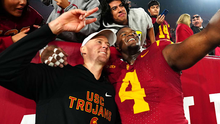 Nov 29, 2025; Los Angeles, California, USA; Southern California Trojans head coach Lincoln Riley (right) and defensive tackle Jahkeem Stewart (4) pose with fans after the game against the UCLA Bruins at United Airlines Field at Los Angeles Memorial Coliseum. Mandatory Credit: Kirby Lee-Imagn Images