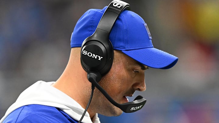 Former New York Giants interim head coach Mike Kafka reviews the playbook during the third quarter against the Detroit Lions 