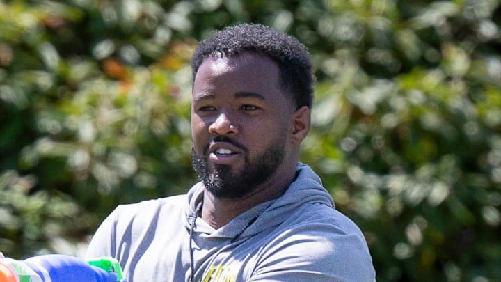 Oregon running backs coach Ra'Shaad Samples sprays running back Jayden Limar during practice with the Ducks Wednesday, Aug. 14 2024 at the Hatfield-Dowlin Complex in Eugene, Ore.