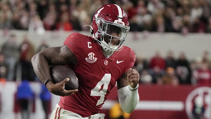 Nov 30, 2024; Tuscaloosa, Alabama, USA; Alabama Crimson Tide quarterback Jalen Milroe (4) runs for a touchdown against Auburn Tigers cornerback Kayin Lee (4) during the second half at Bryant-Denny Stadium. Alabama won 28-14.