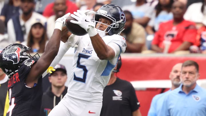 Sep 28, 2025; Houston, Texas, USA; Tennessee Titans wide receiver Elic Ayomanor (5) makes a catch against Houston Texans cornerback Kamari Lassiter (4) during the first half at NRG Stadium. Mandatory Credit: Troy Taormina-Imagn Images
