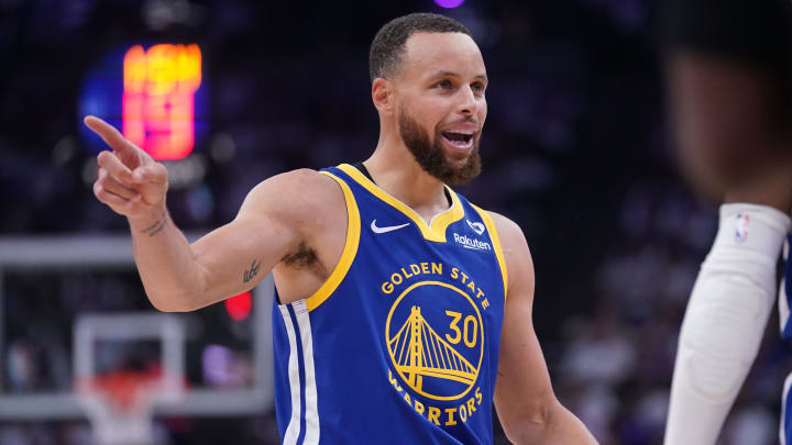 Warriors guard Stephen Curry talks with teammates after a play against the Sacramento Kings during a play-in tournament game.