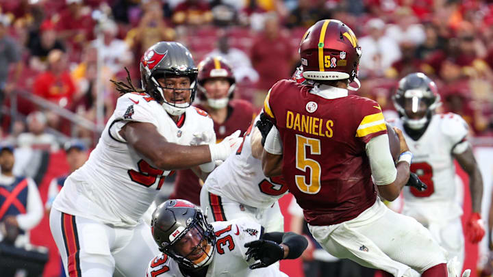 Sep 8, 2024; Tampa, Florida, USA;  Washington Commanders quarterback Jayden Daniels (5) runs the ball for a touchdown against the Tampa Bay Buccaneers in the fourth quarter at Raymond James Stadium. Mandatory Credit: Nathan Ray Seebeck-Imagn Images