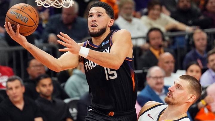 Oct 30, 2026; Phoenix, Arizona, USA; Phoenix Suns guard Devin Booker (15) goes up for a layup against Denver Nuggets center Nikola Jokic (15) during the second half at Mortgage Matchup Center. Mandatory Credit: Joe Camporeale-Imagn Images