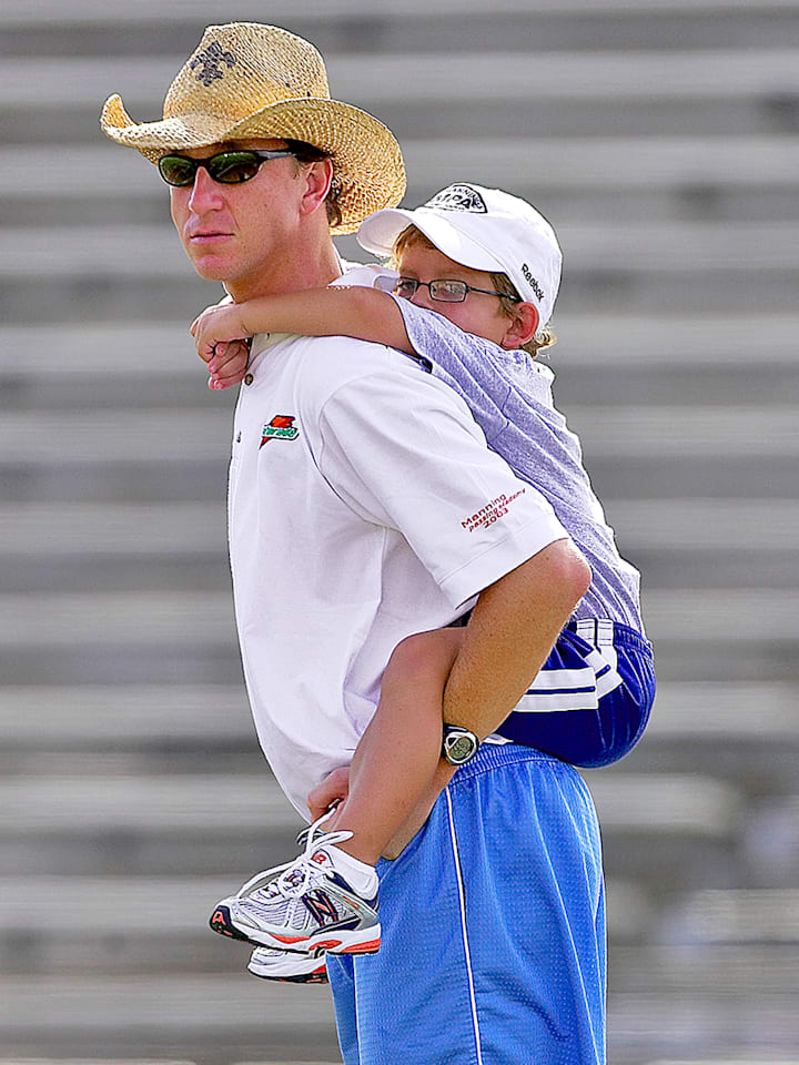 A young Arch Manning on the back of his dad, Cooper, in 2008.