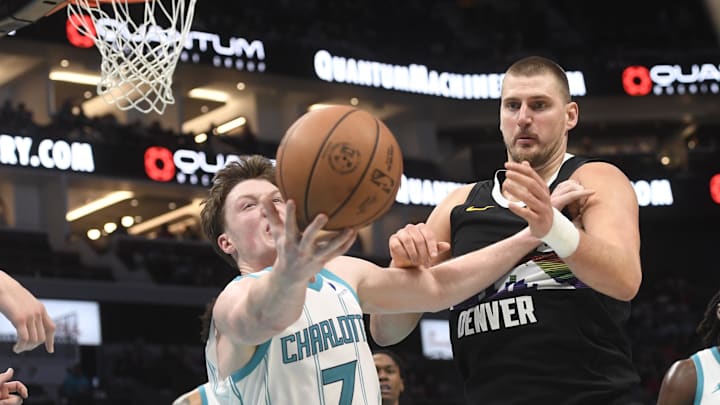 Dec 7, 2025; Charlotte, North Carolina, USA; Charlotte Hornets forward Kon Knueppel (7) and Denver Nuggets center Nikola Jokic (15) go after a loose ball during the second half at the Spectrum Center. Mandatory Credit: Sam Sharpe-Imagn Images