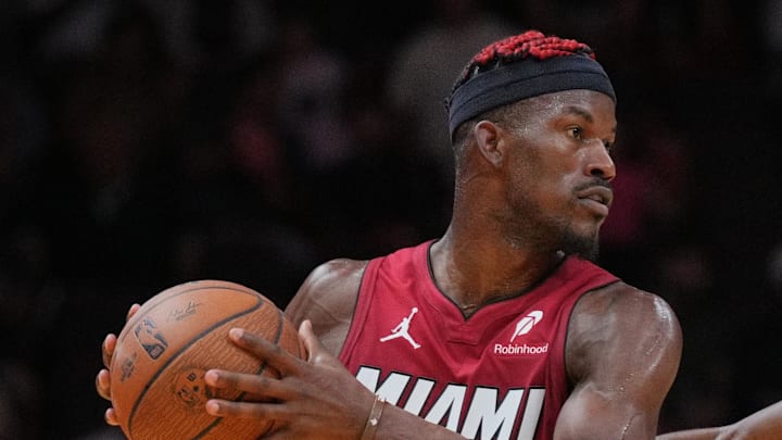 Nov 29, 2024; Miami, Florida, USA;  Miami Heat forward Jimmy Butler (22) looks to pass the ball as Toronto Raptors guard Ja'Kobe Walter (14) defends during the second half in an NBA Cup game at Kaseya Center. Mandatory Credit: Jim Rassol-Imagn Images