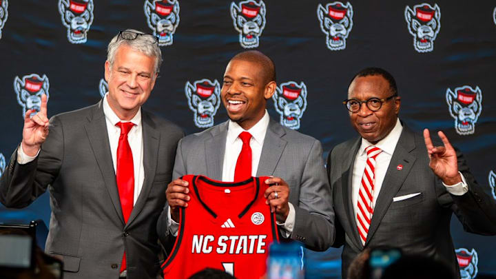 NC State AD Boo Corrigan, men's basketball coach Justin Gainey and Chancellor Kevin Howell pose at Gainey's introductory press conference at the Lenovo Center on Wednesday, April 1, 2026. 
