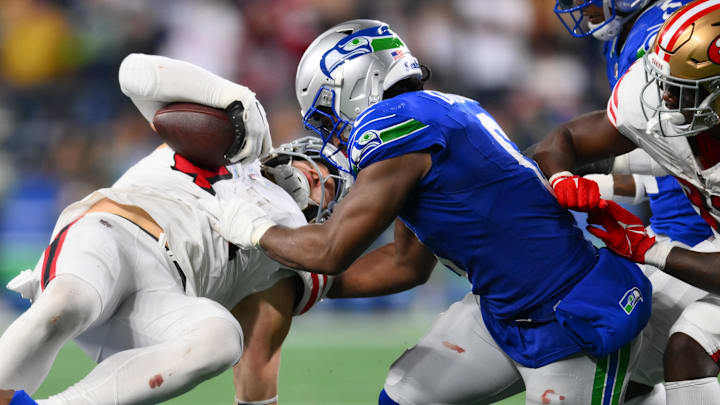 Oct 10, 2024; Seattle, Washington, USA; Seattle Seahawks linebacker Tyrel Dodson (0) tackles San Francisco 49ers fullback Kyle Juszczyk (44) during the second half at Lumen Field. Mandatory Credit: Steven Bisig-Imagn Images