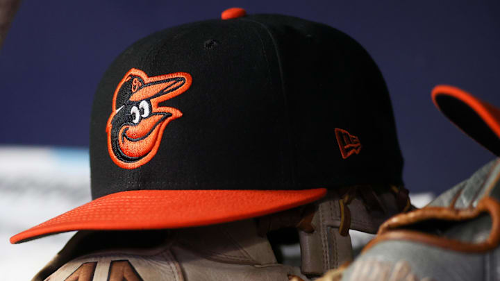 May 5, 2023; Atlanta, Georgia, USA; A detailed view of a Baltimore Orioles hat and glove in the dugout during a game against the Atlanta Braves in the seventh inning at Truist Park.