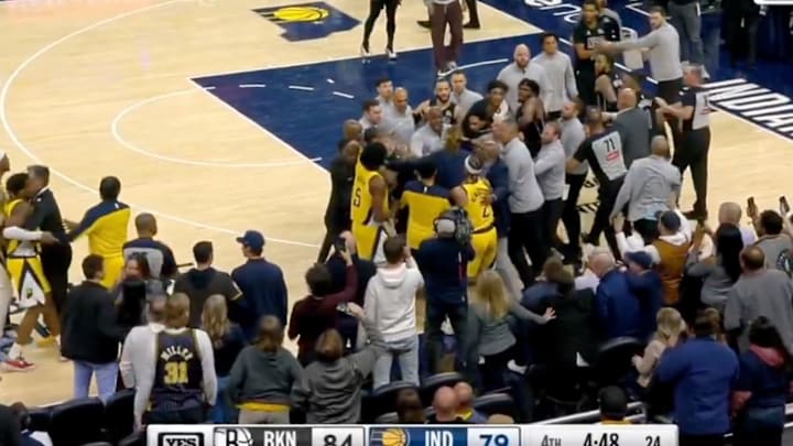 Brooklyn Nets and Indiana Pacers players are separated after a hard foul during a regular season game.