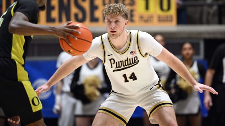 Purdue Boilermakers guard Jack Benter (14) defends against Oregon Ducks guard Takai Simpkins (5).