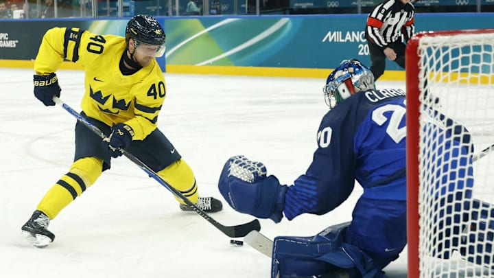 Feb 11, 2026; Milan, Italy; Elias Pettersson of Sweden shoots at goal as Damian Clara of Italy makes a save in men's ice hockey group B play during the Milano Cortina 2026 Olympic Winter Games at Milano Santagiulia Ice Hockey Arena. Mandatory Credit: Geoff Burke-Imagn Images
