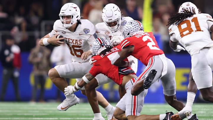 Jan 10, 2025; Arlington, Texas, USA; Texas Longhorns quarterback Arch Manning (16) runs against Ohio State Buckeyes cornerback Jordan Hancock (7) and safety Caleb Downs (2) during the second quarter of the College Football Playoff semifinal in the Cotton Bowl at AT&T Stadium. Mandatory Credit: Tim Heitman-Imagn Images