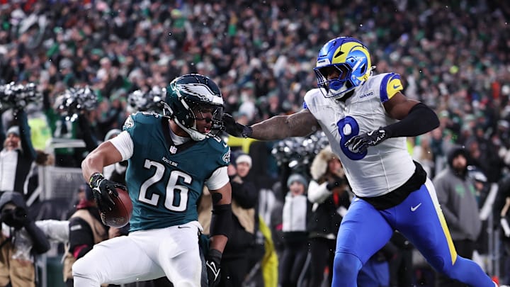 Jan 19, 2025; Philadelphia, Pennsylvania, USA; Philadelphia Eagles running back Saquon Barkley (26) scores a touchdown past Los Angeles Rams linebacker Jared Verse (8) in the first half in a 2025 NFC divisional round game at Lincoln Financial Field. Mandatory Credit: Bill Streicher-Imagn Images