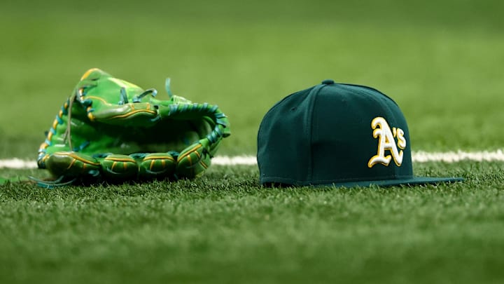 Jul 22, 2025; Arlington, Texas, USA;  Athletics glove and hat on the field before the game against the Texas Rangers at Globe Life Field. Mandatory Credit: Kevin Jairaj-Imagn Images